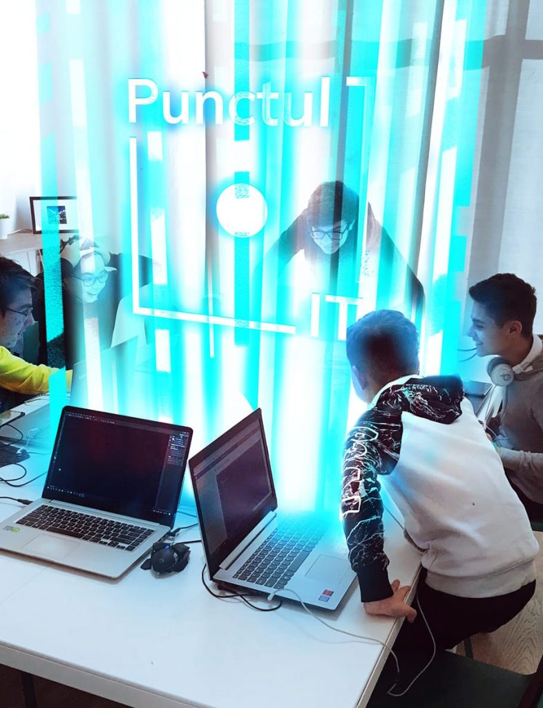 Copii lucrând împreună la o masă cu laptopuri și accentul grafic Punctul IT